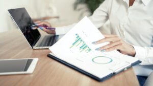 A freelance woman in the office is working with documents on a report.