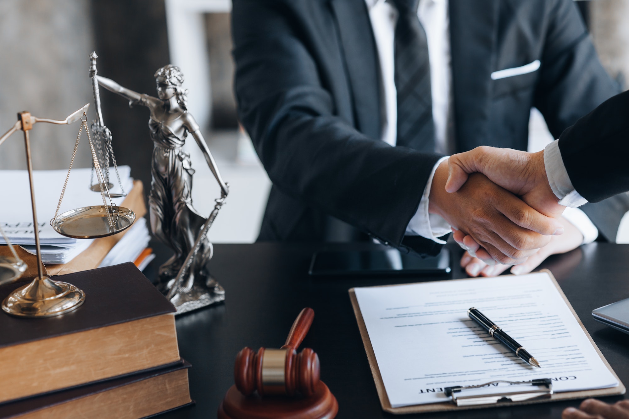 Lawyer and client shake hands, after winning a lawsuit where a lawyer hired.