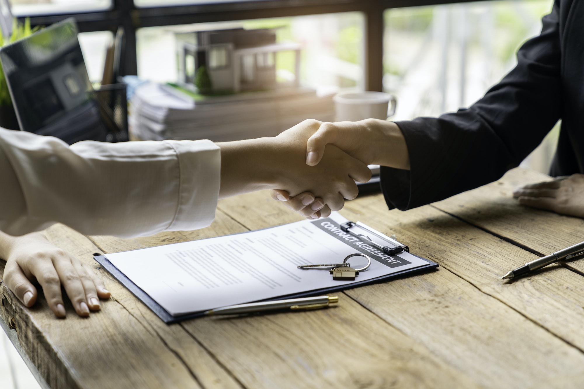 real estate agents shaking hands with customers after accepting an agreement to finish buying or ren